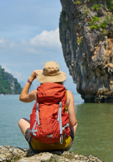Traveller with a backpack looking out over a coastal viewpoint
