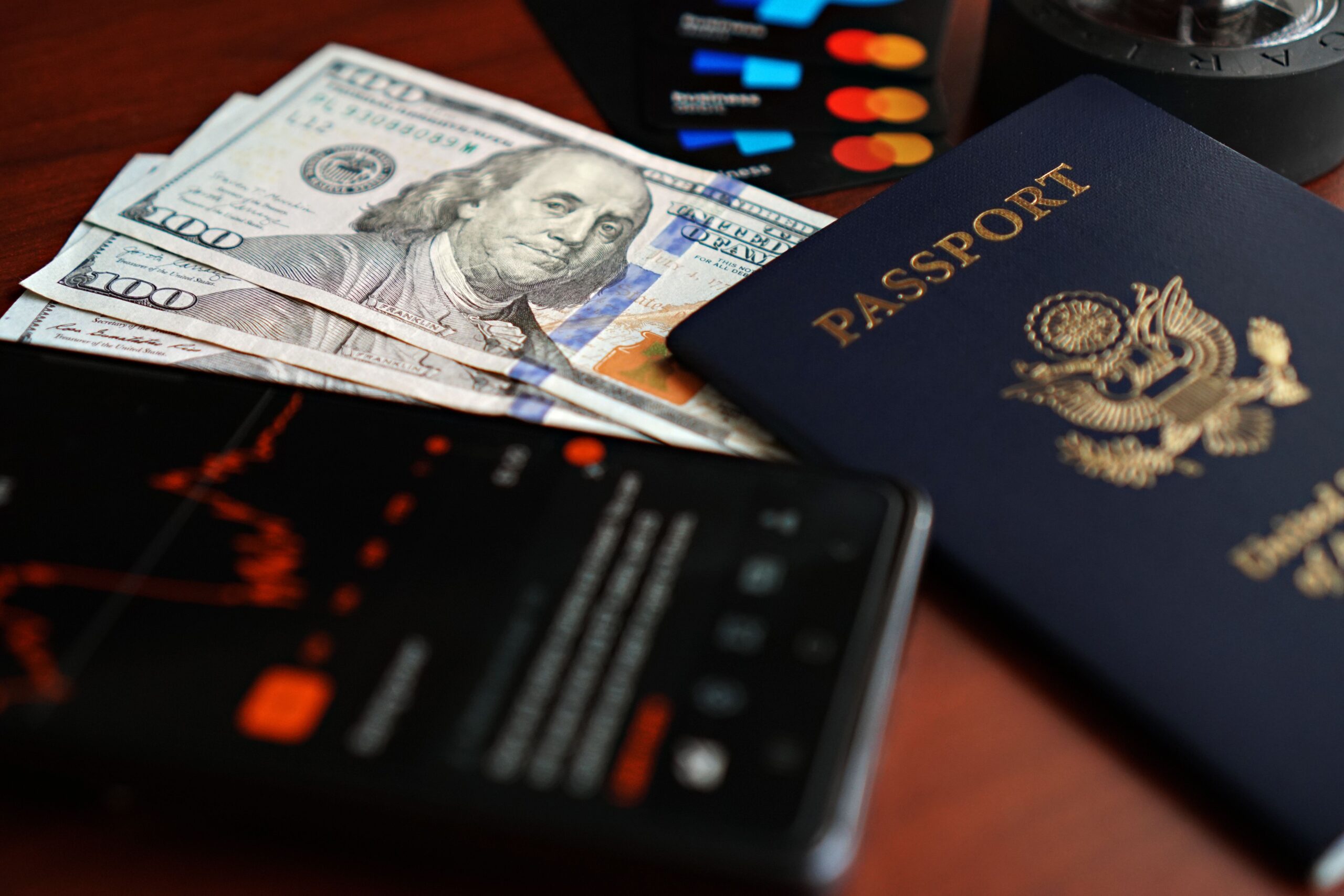 Passport, currency and a mobile phone on a desk