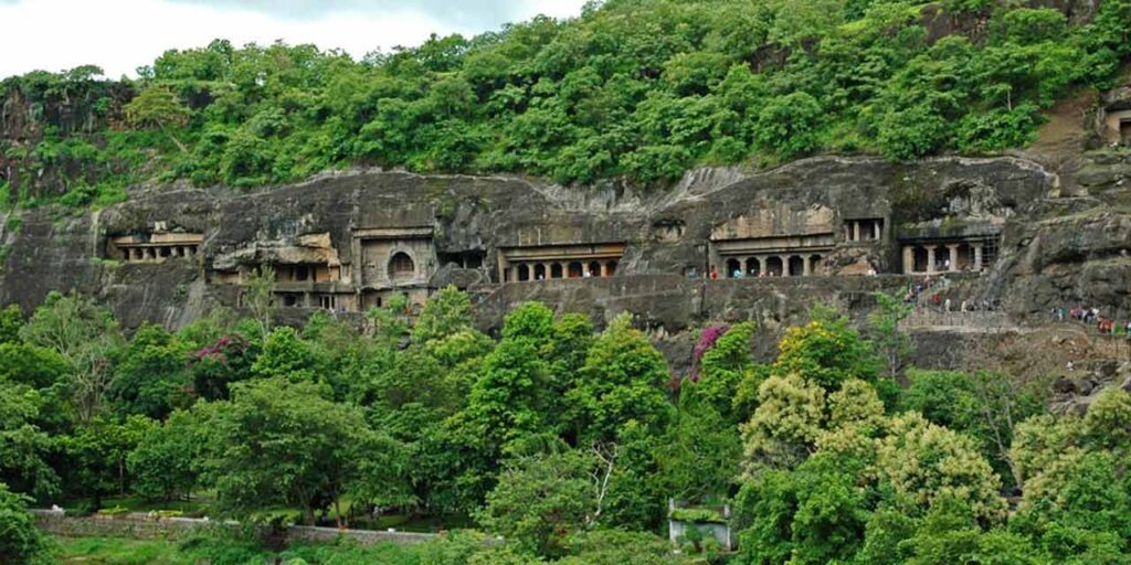 The Ajanta Caves along a forested horseshoe-shaped cliff, near Aurangabad