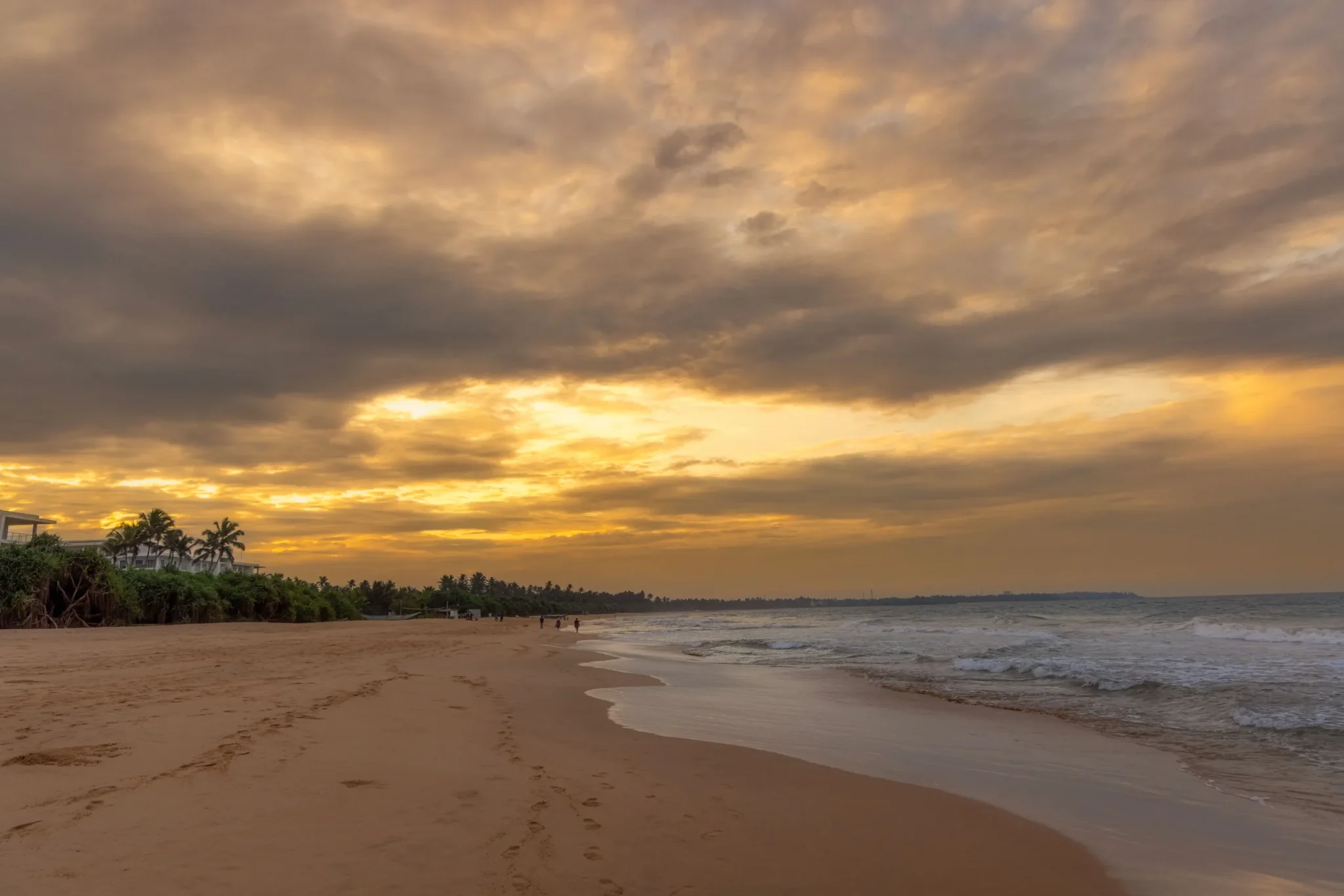 Empty Bentota beach under a golden sunset sky
