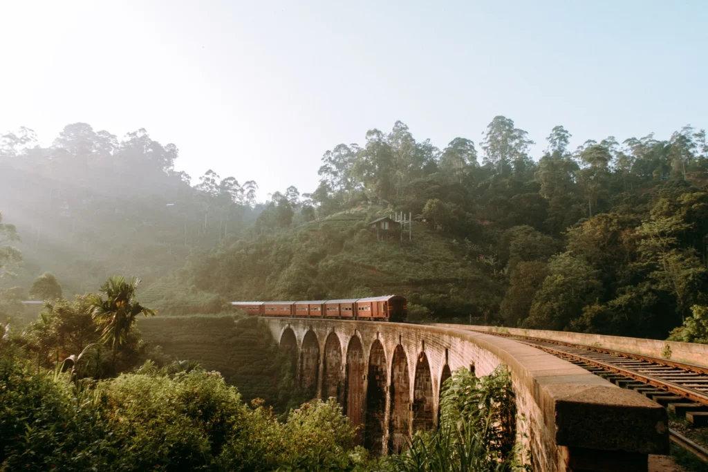 Train crossing Nine Arches Bridge near Ella in warm morning light