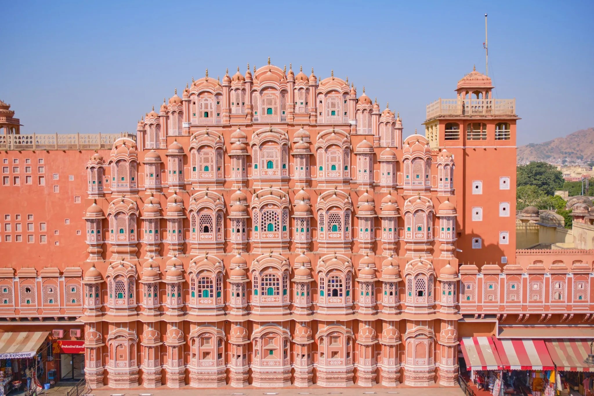 Pink honeycomb facade of Hawa Mahal in Jaipur under a blue sky