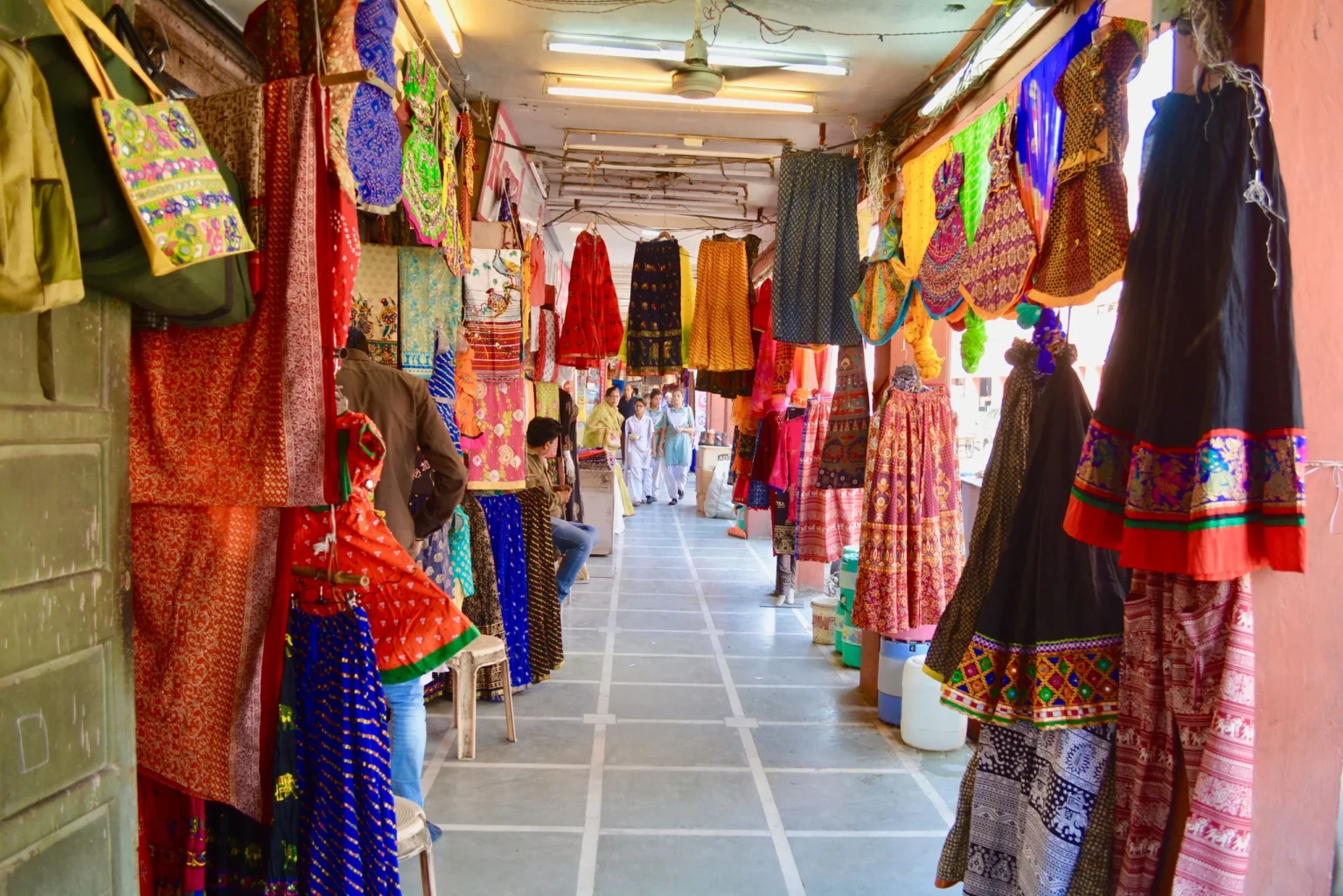 Jaipur bazaar arcade hung with colourful Rajasthani textiles
