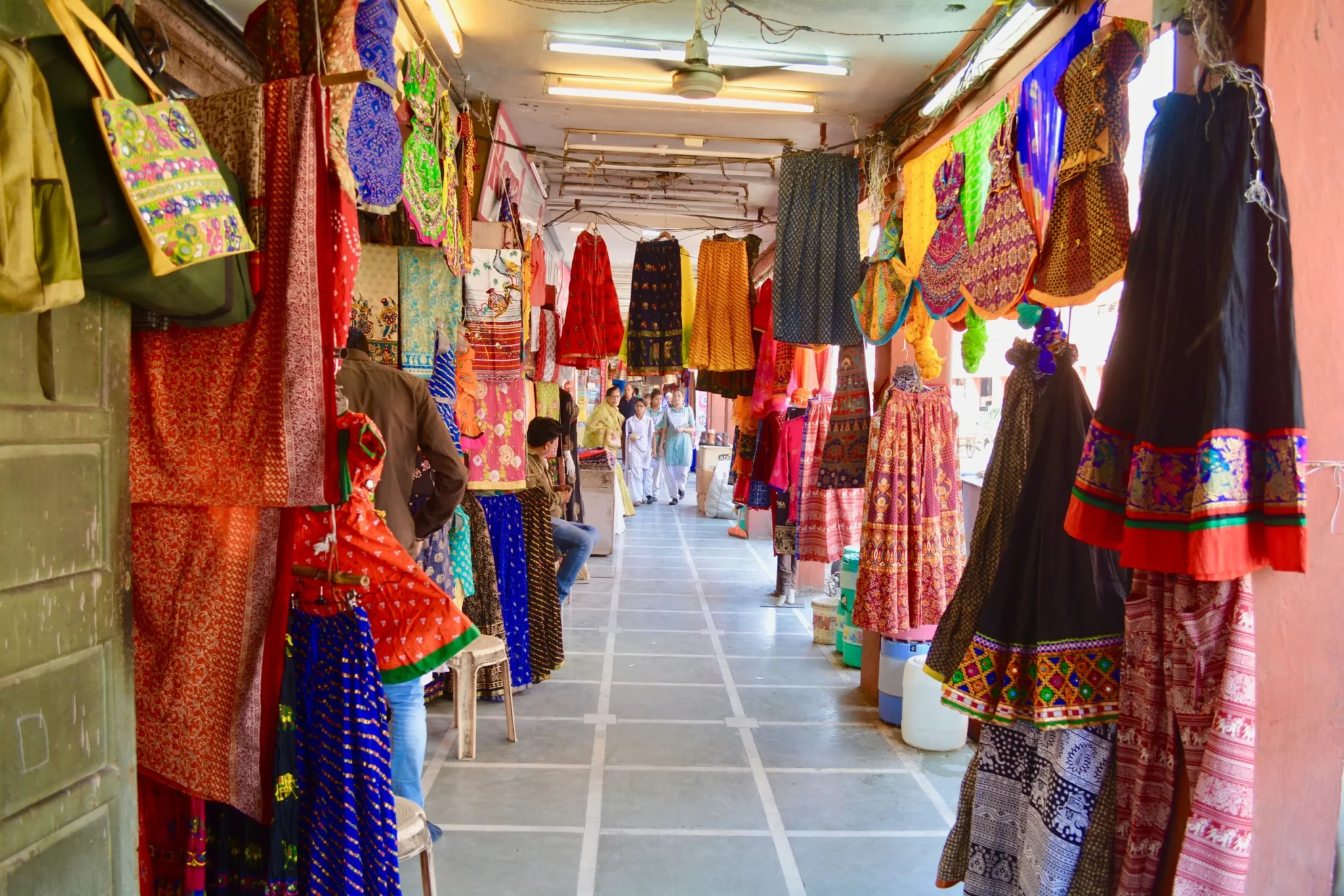 Jaipur bazaar arcade hung with colourful Rajasthani textiles