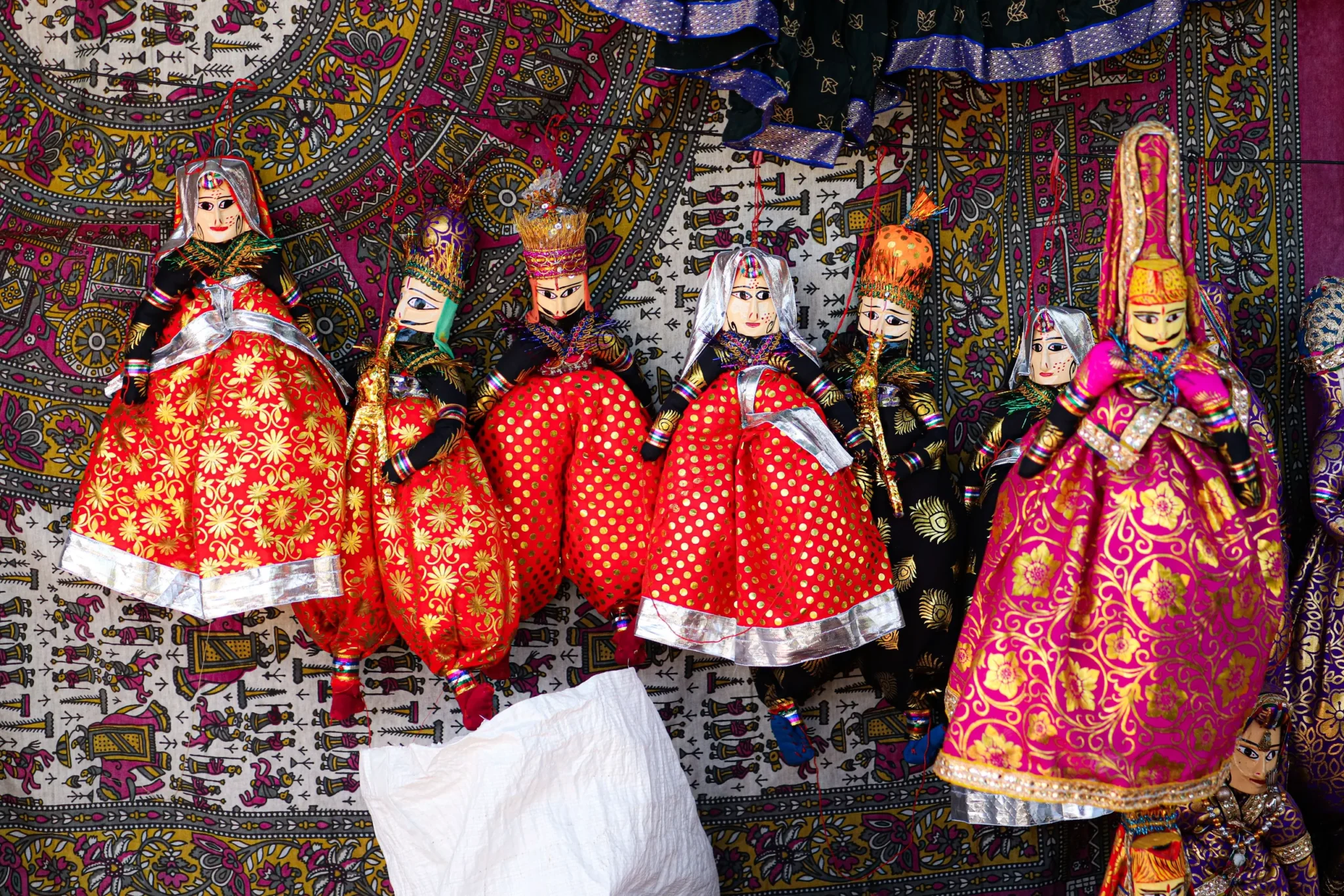 Colourful Rajasthani string puppets hanging at a Jaipur market stall