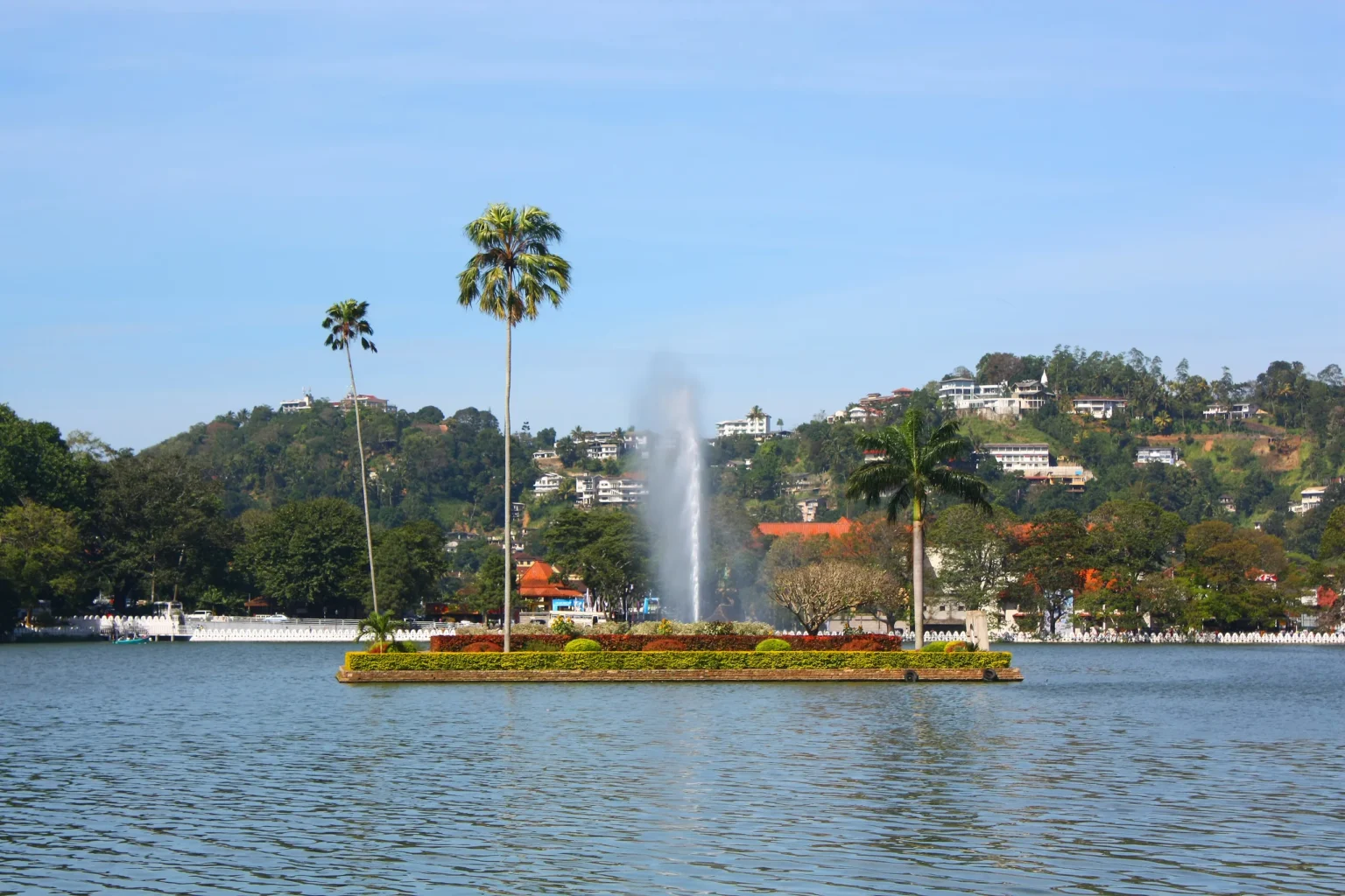 Island with palms and a fountain in Kandy Lake