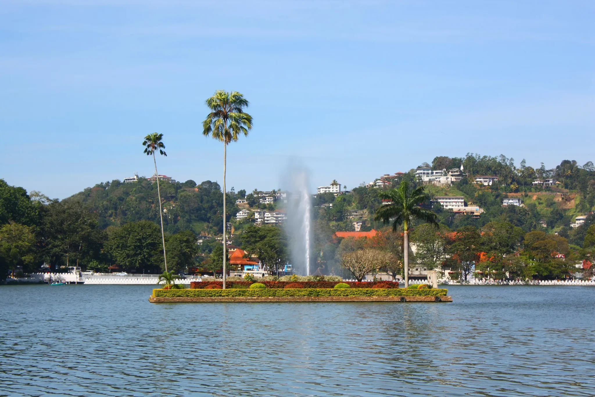 Island with palms and a fountain in Kandy Lake