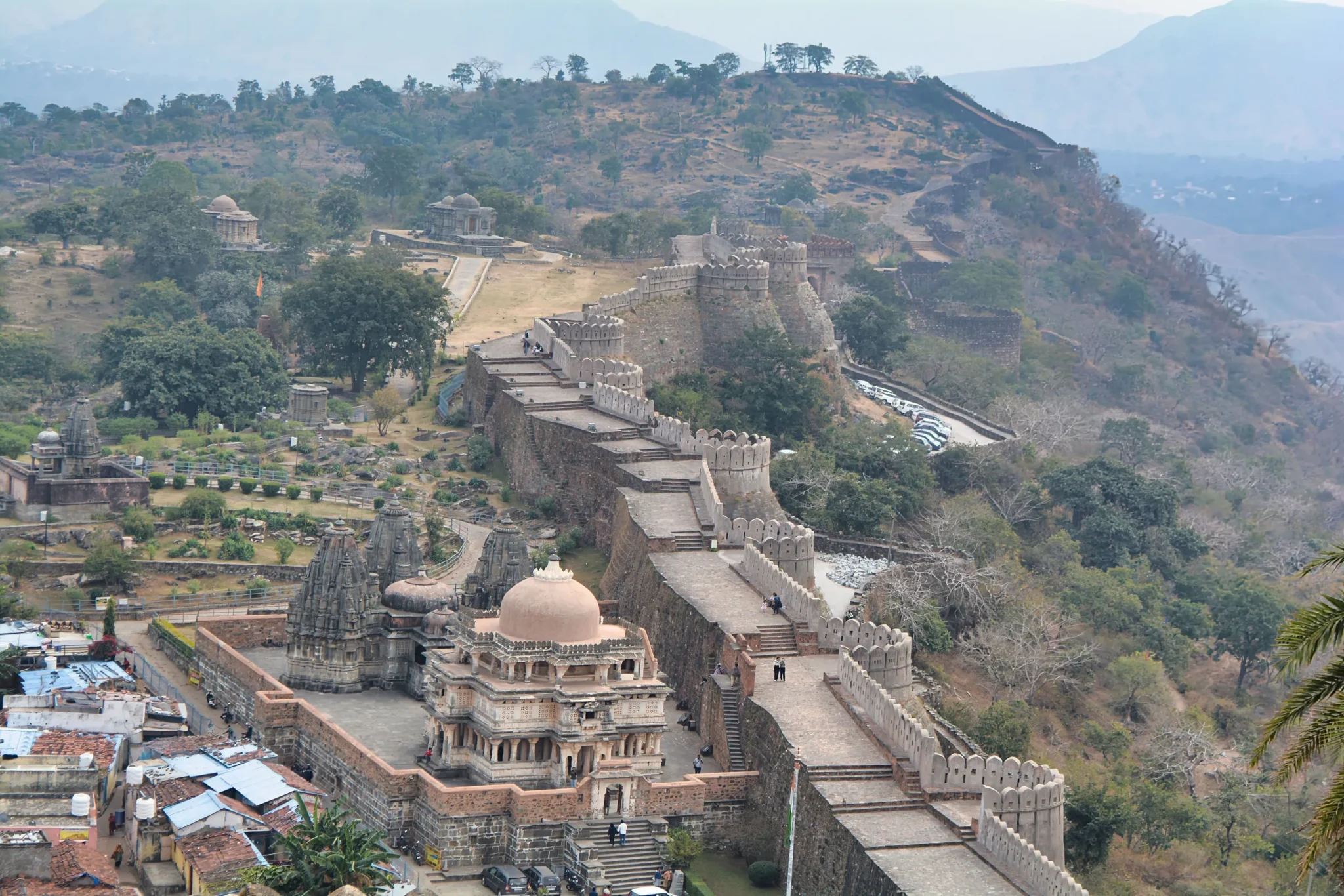 Kumbhalgarh fort walls and temples seen from above, hills beyond