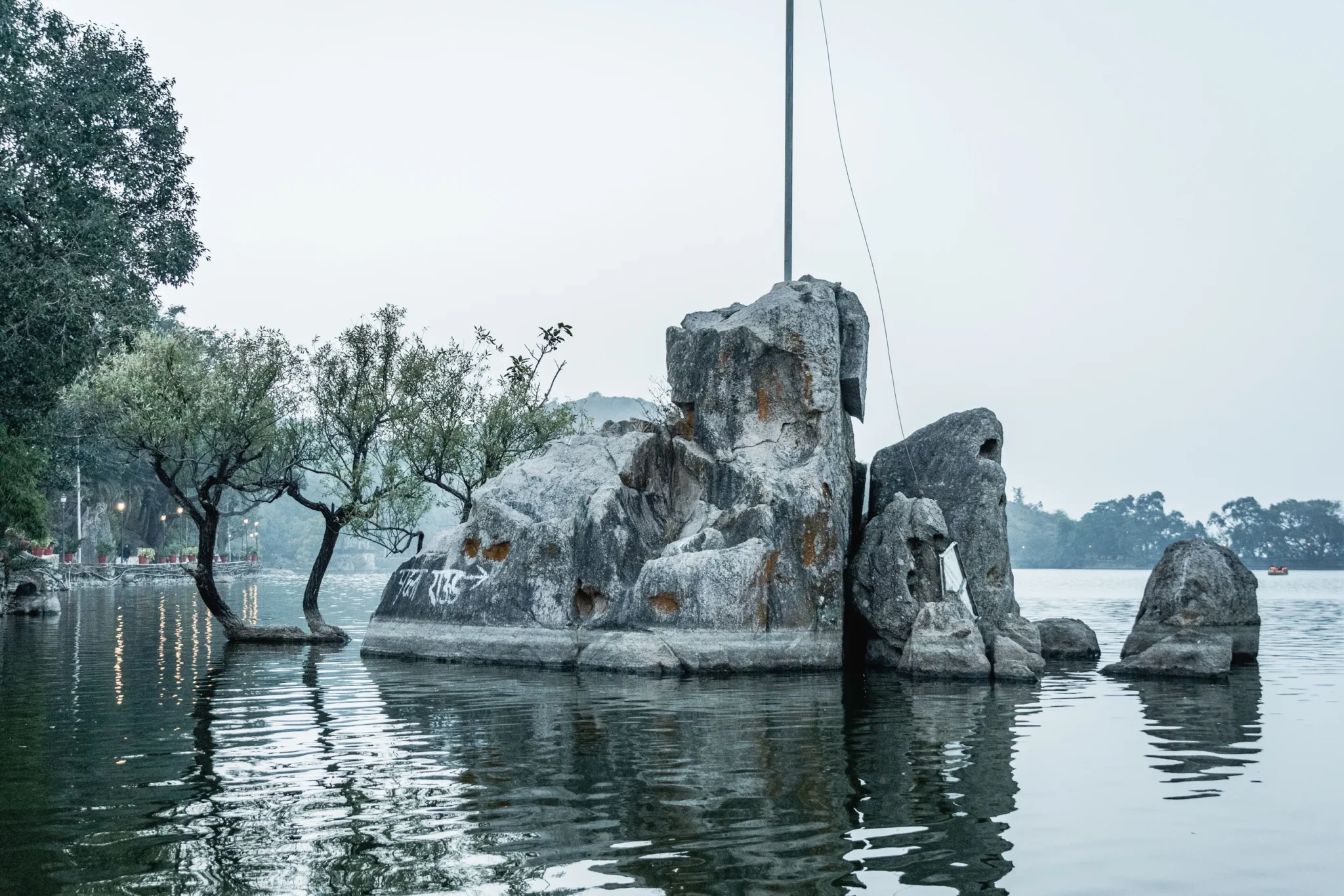 Rock formations and trees reflected in Nakki Lake, Mount Abu