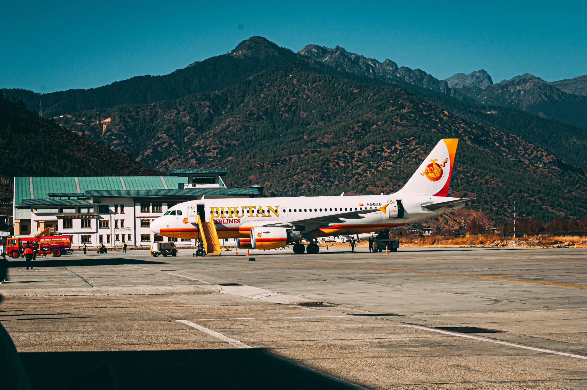 A plane at Paro airport with the mountains behind