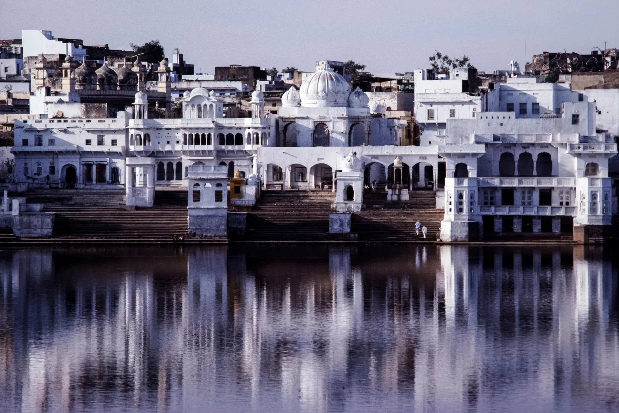 White ghat buildings of Pushkar reflected in the still lake