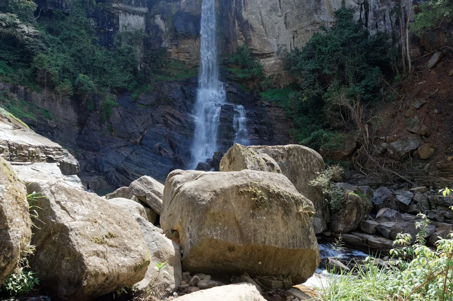Ramboda Falls tumbling over a cliff above large boulders