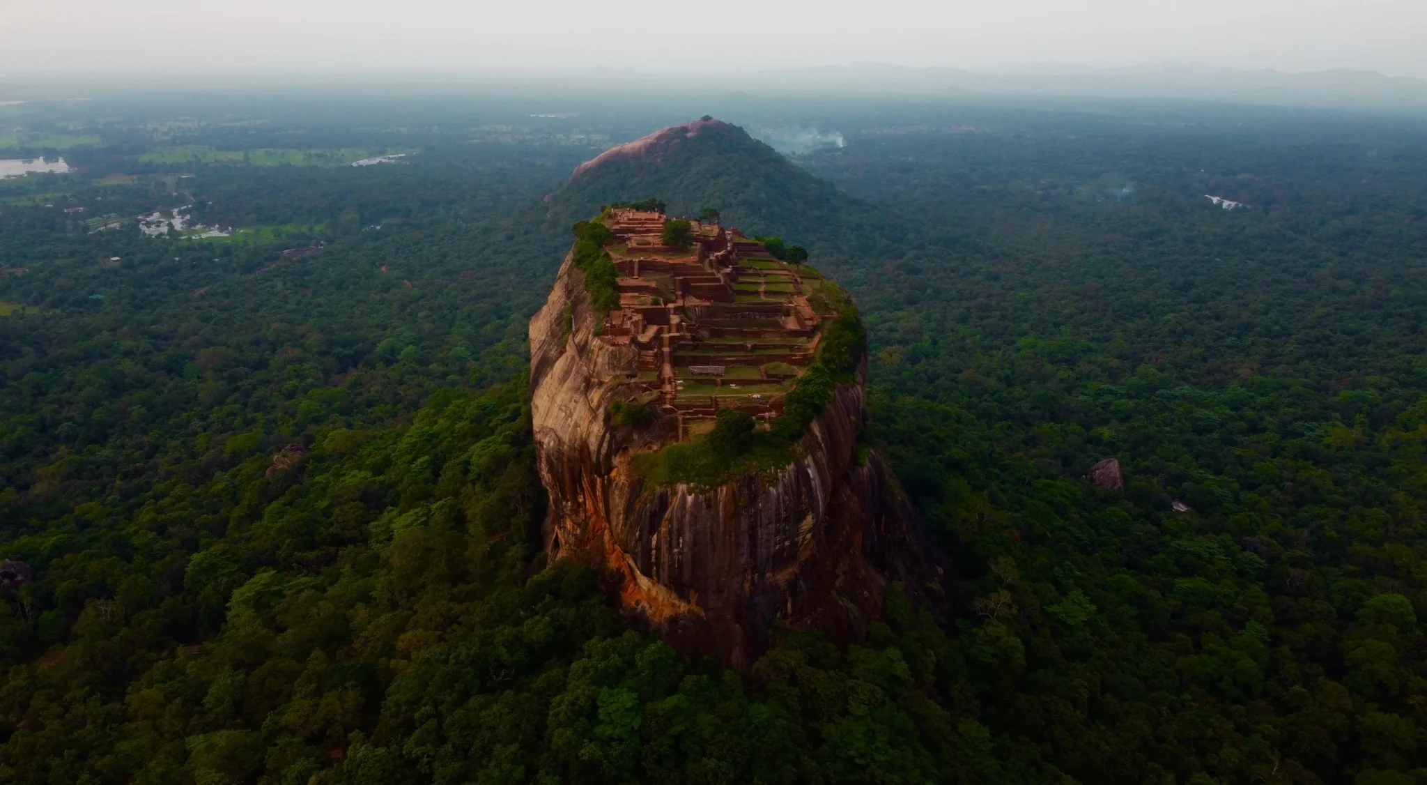 Aerial view of Sigiriya Rock rising out of the green forest