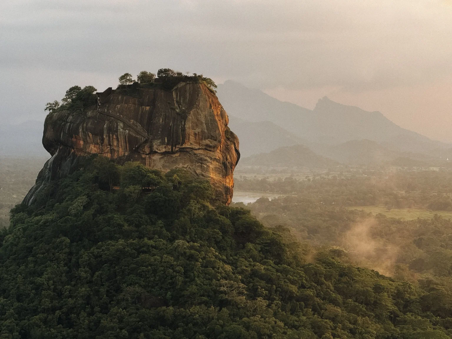 Sigiriya Rock in morning mist with hills behind