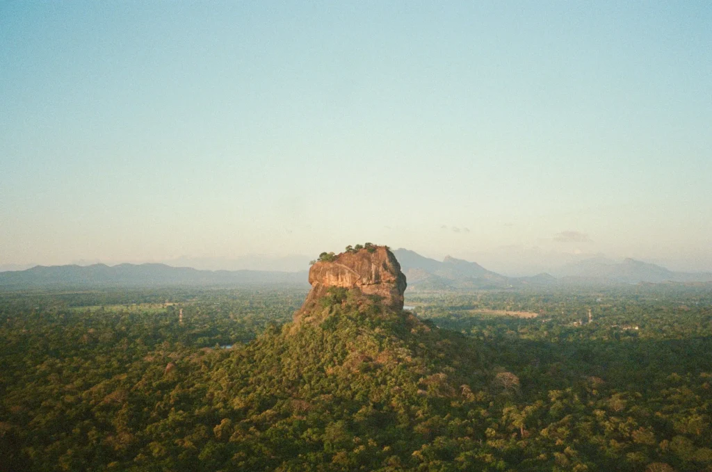 Sigiriya Rock at sunrise above a wide forested plain