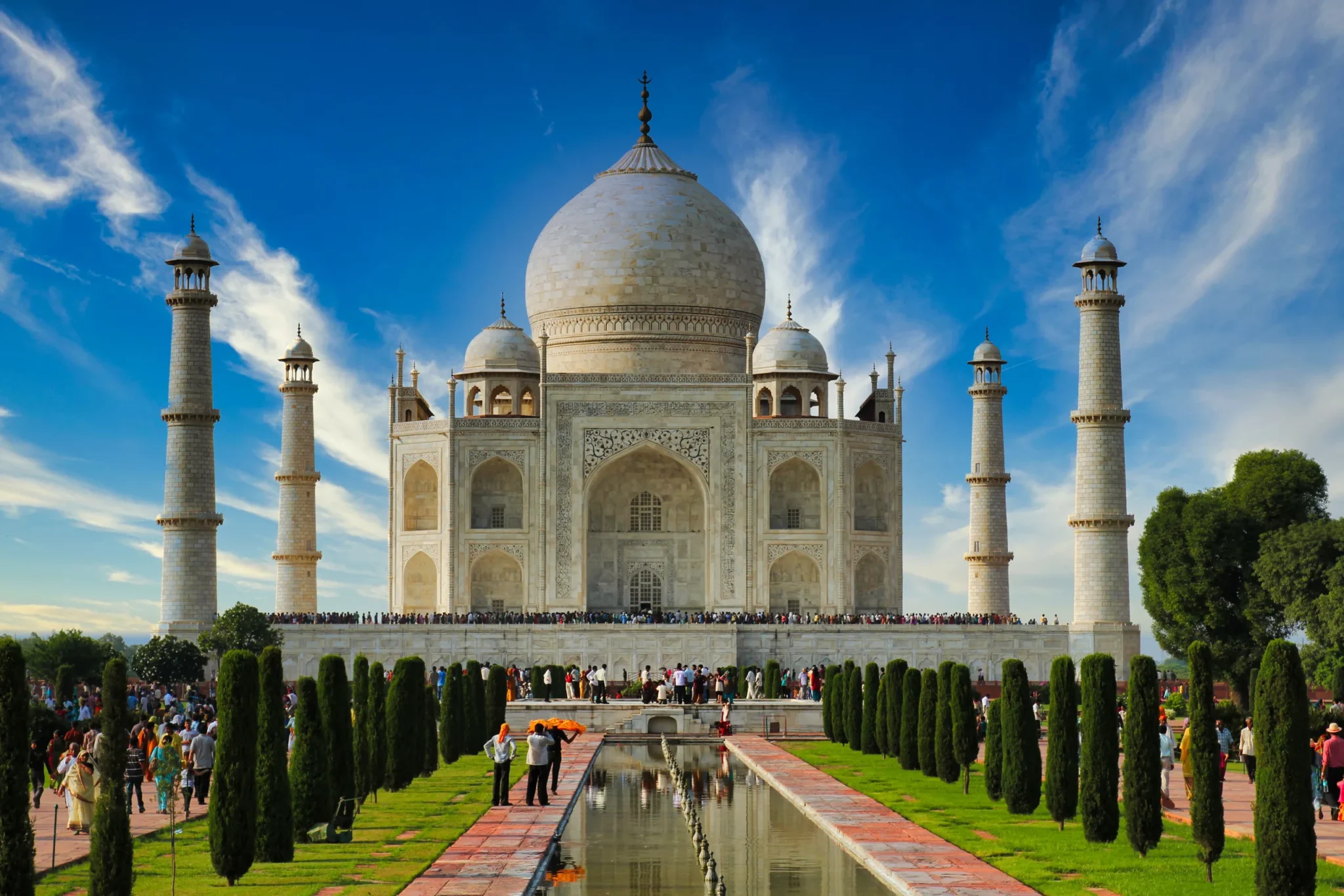 Taj Mahal and minarets under a blue sky with streaky clouds