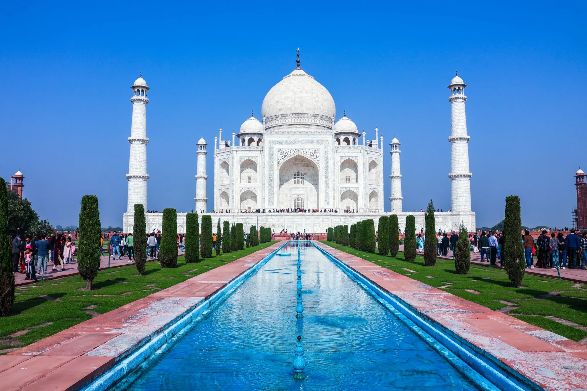 Taj Mahal beyond the water channel under a clear blue sky