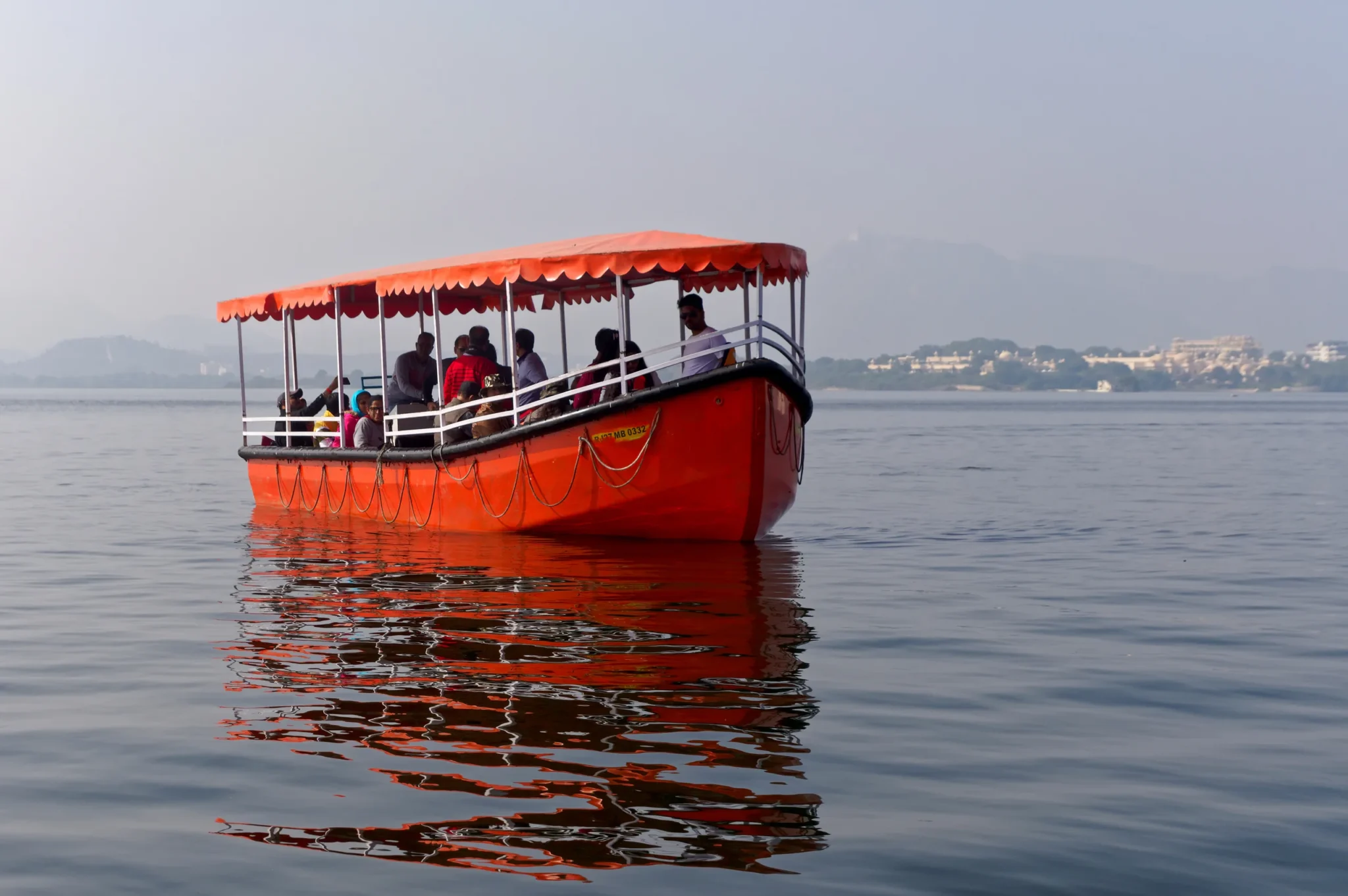 Red tourist boat cruising on Lake Pichola in Udaipur